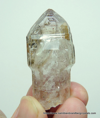 Light smoky quartz crystal with moving bubble and inclusions