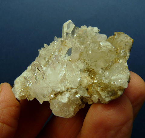 Mostly clear quartz crystals sit on a basalt matrix.
