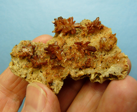 Iron oxide coated quartz crystal clusters on matrix