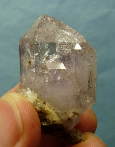 Faint amethyst quartz crystal with inclusions, on small matrix