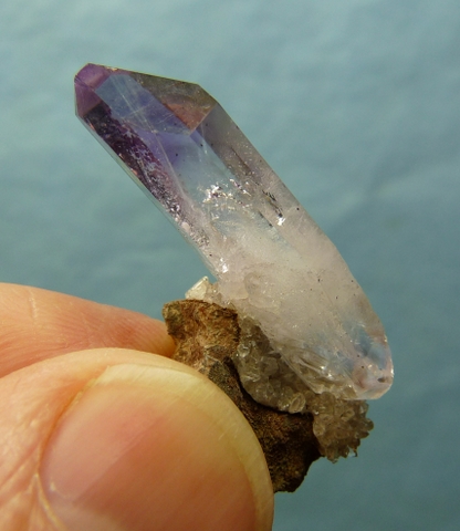 Quartz crystal with amethyst upper part, on matrix