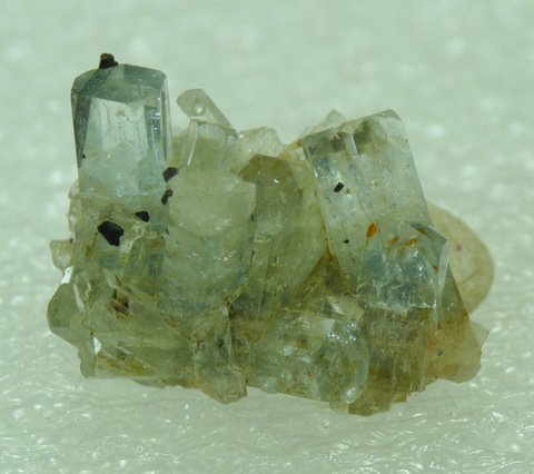 Group of small aquamarine crystals with bits of schorl