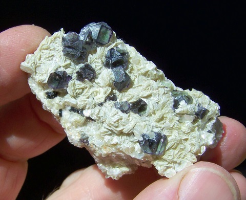 Green fluorite crystals with purple edges, on muscovite and feldspar