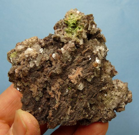 Small, clear calcite crystals with bits of (?)duftite, on matrix