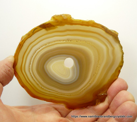 A slice of polished agate with a hole