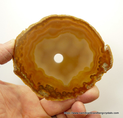 A slice of polished agate with a hole in